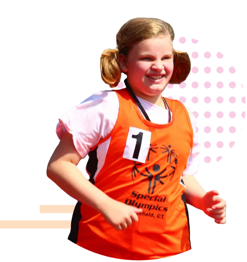 Youth female athlete with her hair in pigtails running wearing an orange Special Olympics jersey over a pink t-shirt.