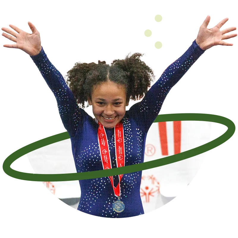 Girl wearing medal with hands raised in air