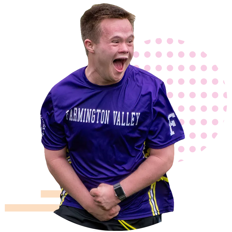 Youth female athlete with her hair in pigtails running wearing an orange Special Olympics jersey over a pink t-shirt.